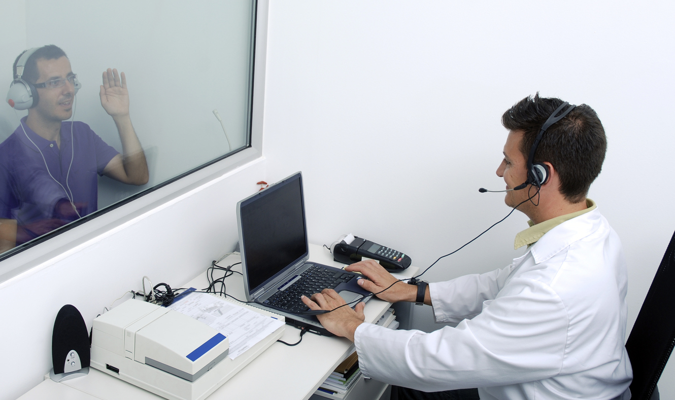 Audiometer hearing test Doctor doing a hearing test to a patent with an audiometer. Real doctor and patient, not modedls.